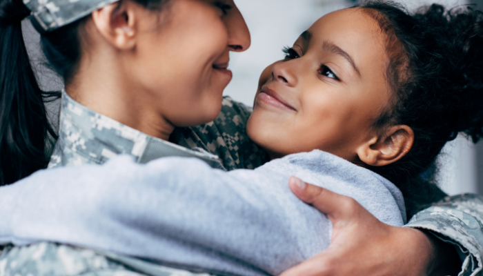 Military mom hugs young daughter