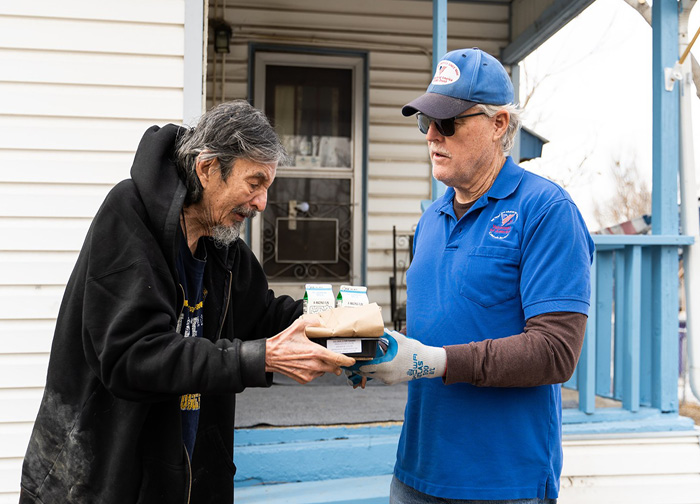 Homeless senior man receives hot meal